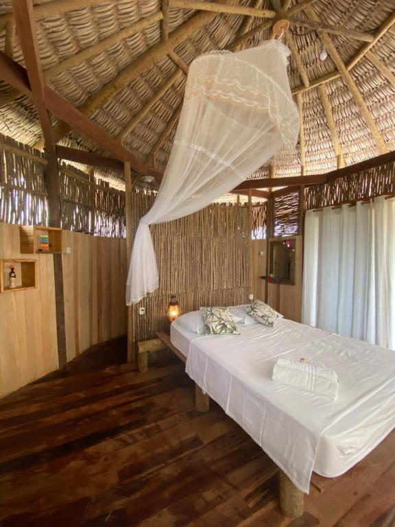 a bedroom with a bed with a mosquito net at Cabanadu Preá Kite in Prea