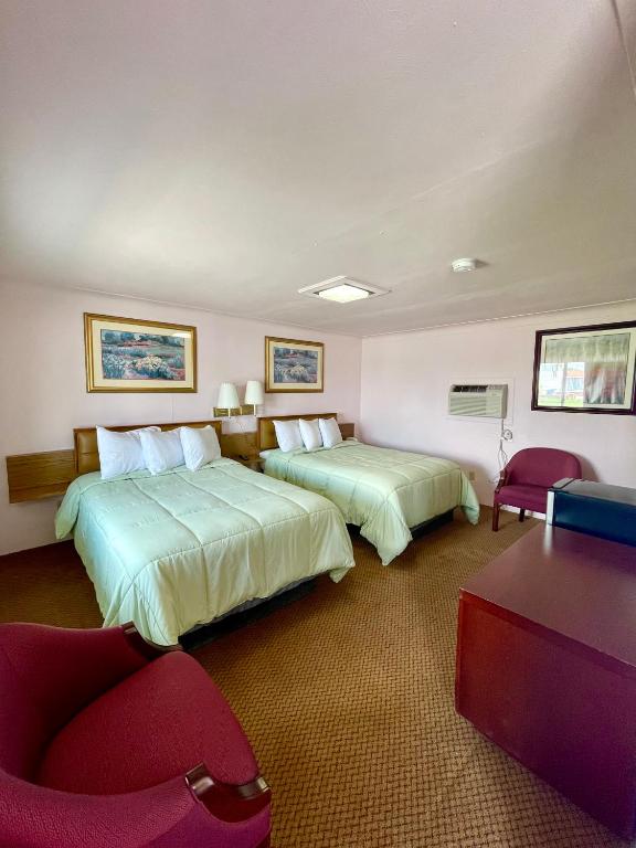 a hotel room with two beds and a desk and chairs at Best Motel Bowling Green in Bowling Green