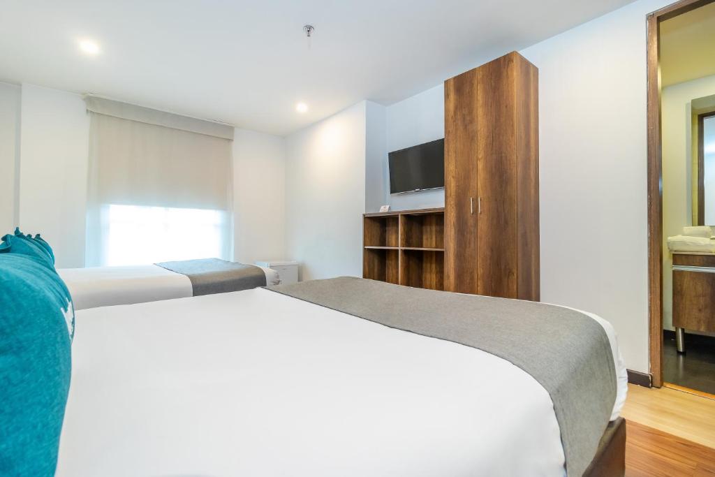 Postel nebo postele na pokoji v ubytování Hotel Black Usaquen