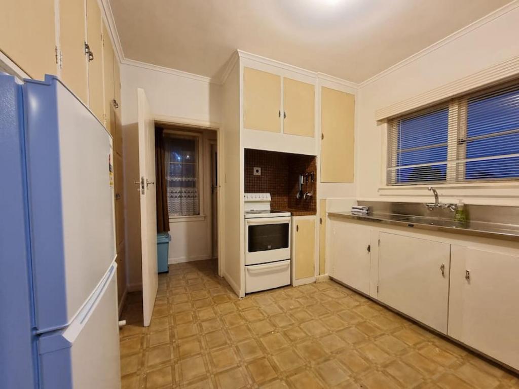 uma cozinha com um lavatório e um fogão forno superior em Cozy 3BR Mt Roskill - Heat Pump & Wifi & Netflix em Auckland