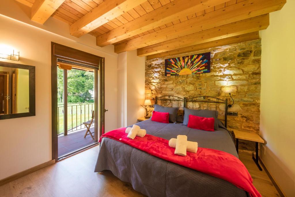 ein Schlafzimmer mit einem Bett und einer Steinwand in der Unterkunft LA PANDELA in Las Herrerías