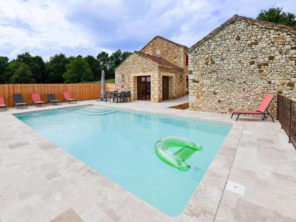 una piscina frente a una casa de piedra en Majestic holiday home with swimming pool, en Prats-du-Périgord