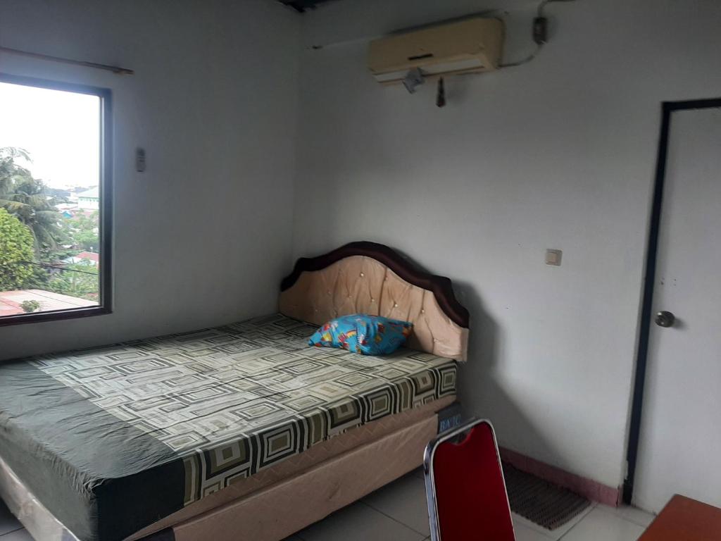 a small bedroom with a bed and a window at SPOT ON 90535 Cimanuk Pavilion in Bengkulu