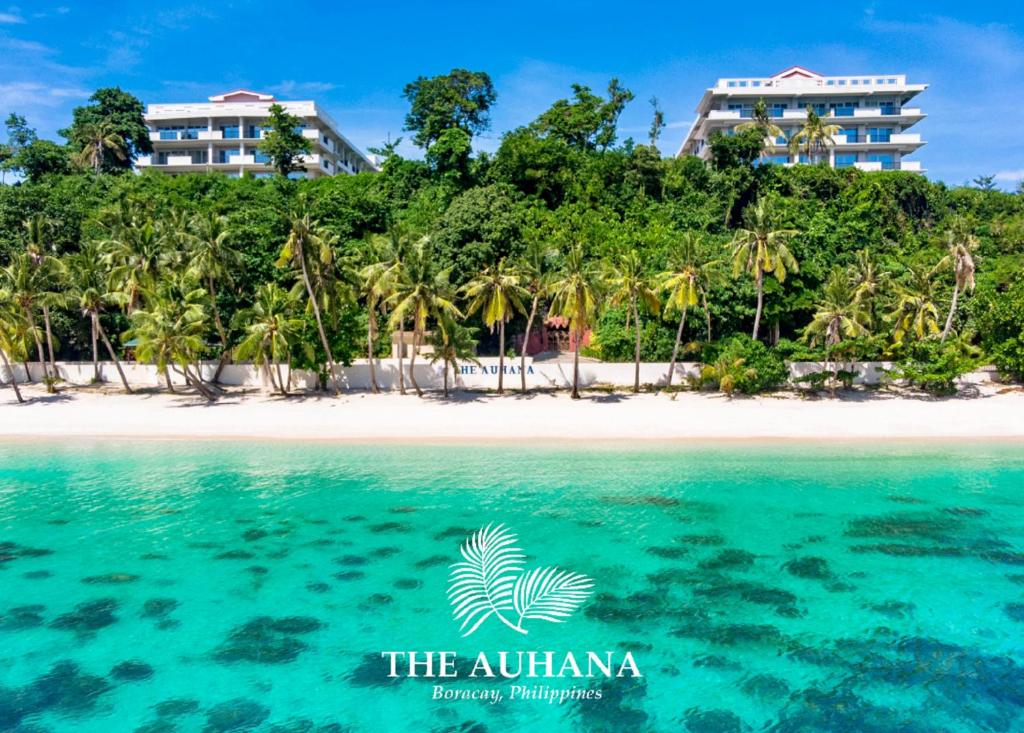 an island in the ocean with palm trees and a beach at The Auhana in Boracay
