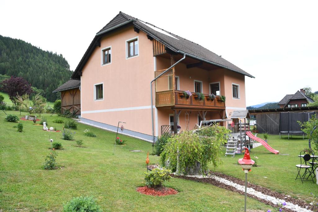 a house with a garden and a playground at Ferienwohnung Moser in Sankt Blasen