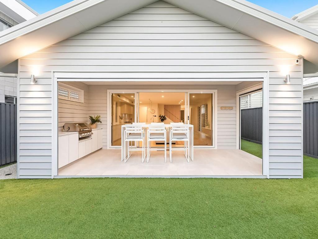 a white house with a patio with a table at Nautilus Ocean Breeze in Kingscliff