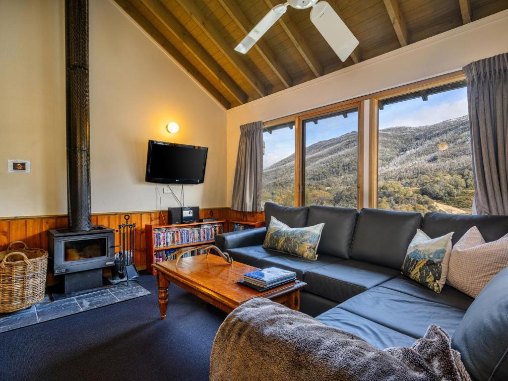 a living room with a couch and a fireplace at Banjo Apartments in Thredbo