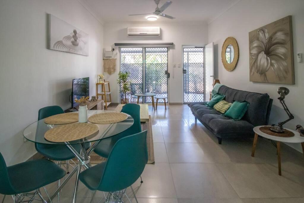 a living room with a couch and a table and chairs at ZEN GARDEN - COZY 2-BR + Modern Design w/ Aircon in Casuarina