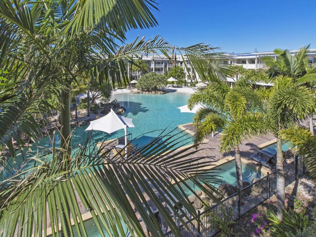 an aerial view of a resort pool with palm trees at Resort & Spa 6316 with resort Tropical Pool in Kingscliff