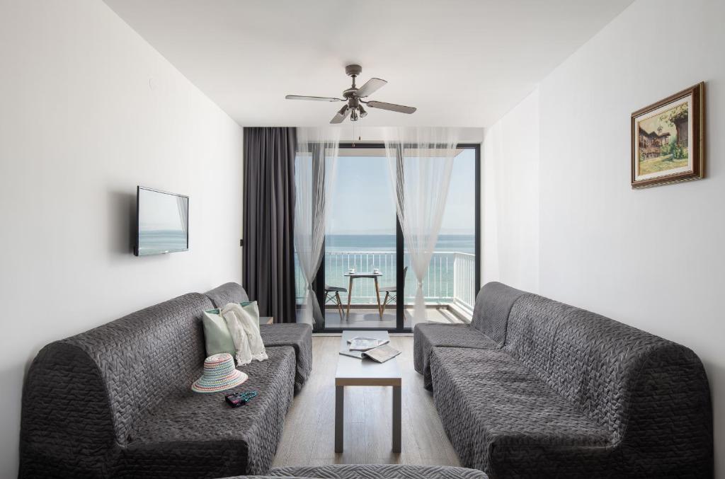 a living room with two couches and a view of the ocean at Grand Dodo's Triada Seaview Studios in Agia Triada
