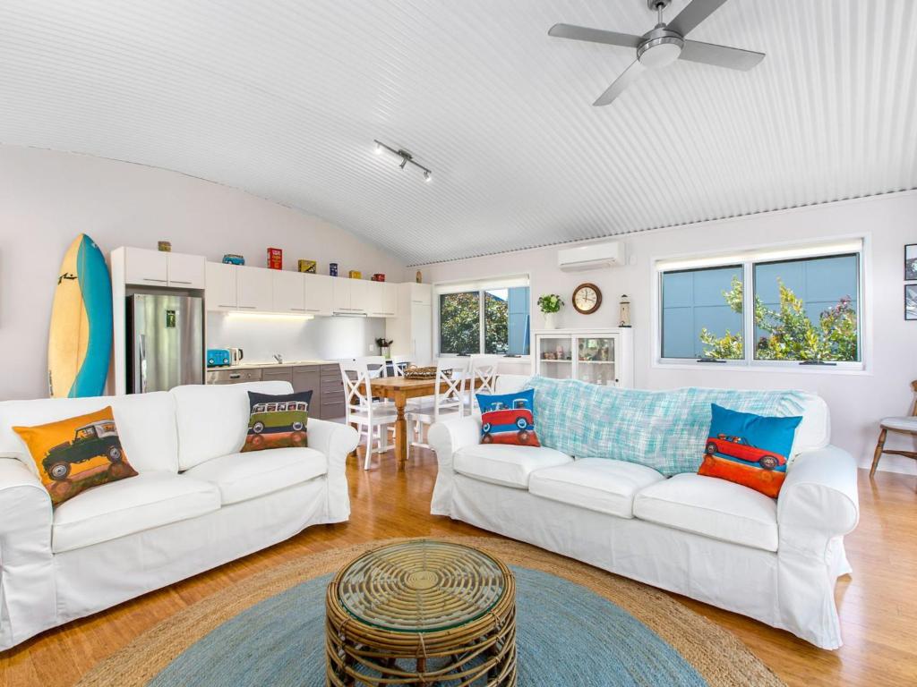 a living room with two white couches and a table at Casuarina Beach Shacks 10 with Pool in Kingscliff