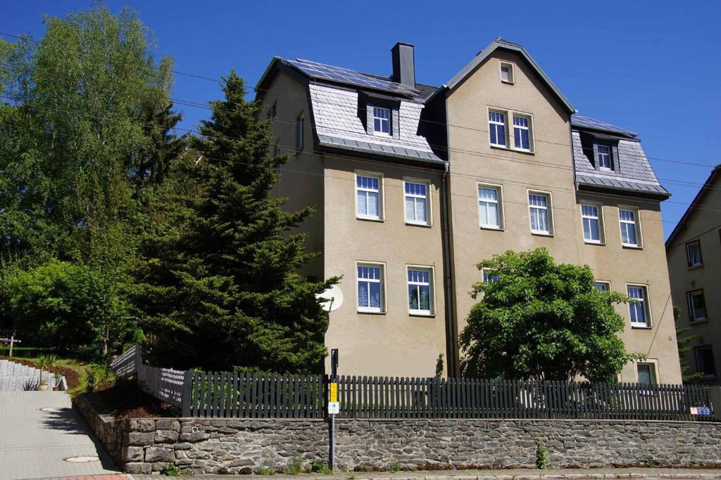 a large house with a fence in front of it at Ferienwohnung KerMärchen in Gelenau