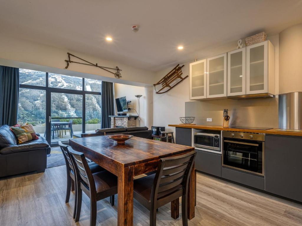 a kitchen with a wooden table and chairs in a room at Lantern 2 bedroom Terrace with panoramic mountain view in Thredbo