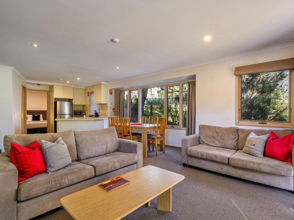 a living room with two couches and a table at Lhotsky 1 Bedroom apartment with tranquil outlook and onsite parking in Thredbo