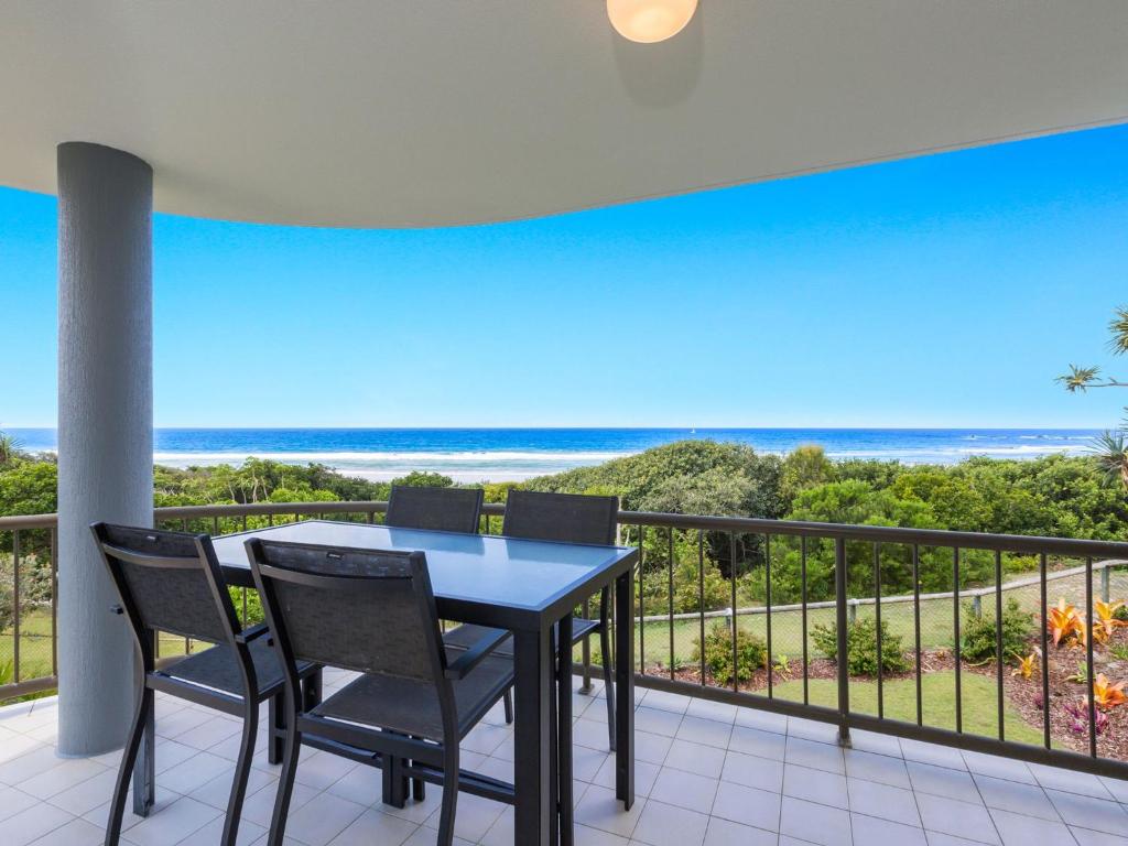 
a dining room table with a balcony overlooking the ocean at Shoreline Six With Ocean Views To See The Whales in Hastings Point
