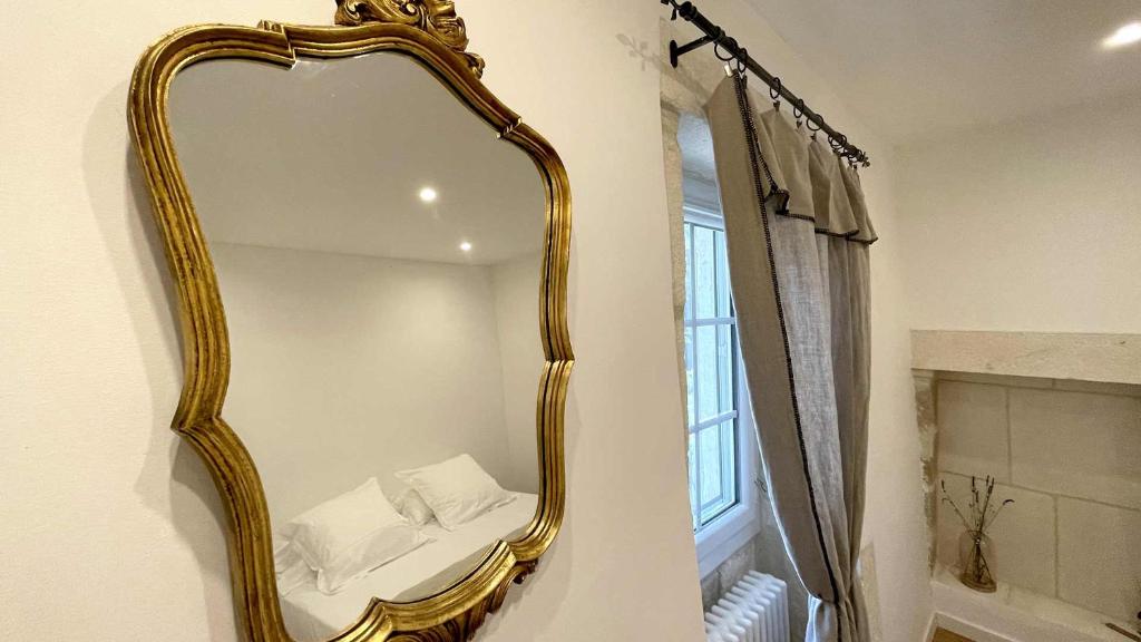a gold mirror on a wall in a bathroom at MAS MILLÉSIME - Chambre double - petit déjeuner - piscine - Mas du XVIIIème siècle proche Saint-Rémy-de-Provence in Mas blanc des Alpilles