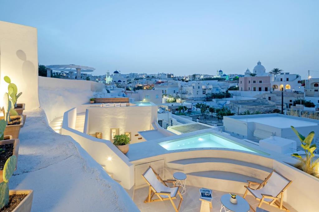 a villa with a swimming pool on top of a building at Utopia Suites Santorini in Karterados