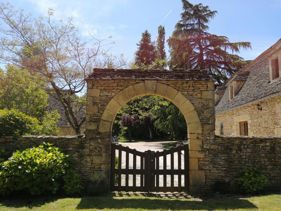 einen Torbogen in einer Ziegelmauer mit einem Tor in der Unterkunft Domaine de Pech Mortier in Marcillac-Saint-Quentin