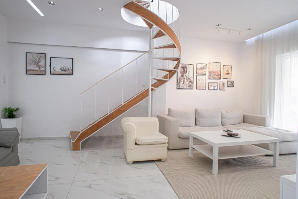 uma sala de estar com uma escada, um sofá e uma mesa em Luxury Apt 115m2 em Atenas