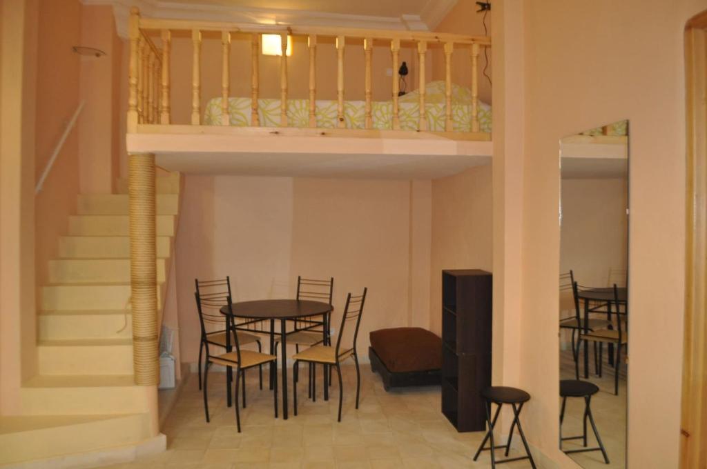 une chambre avec une table, des chaises et une mezzanine dans l'établissement Studio Mezzanine Kasbah Tanger - Climatisée, à Tanger