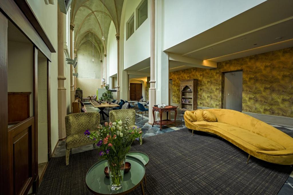 a living room with a bed with a yellow blanket at EgliZen in Hoofdplaat