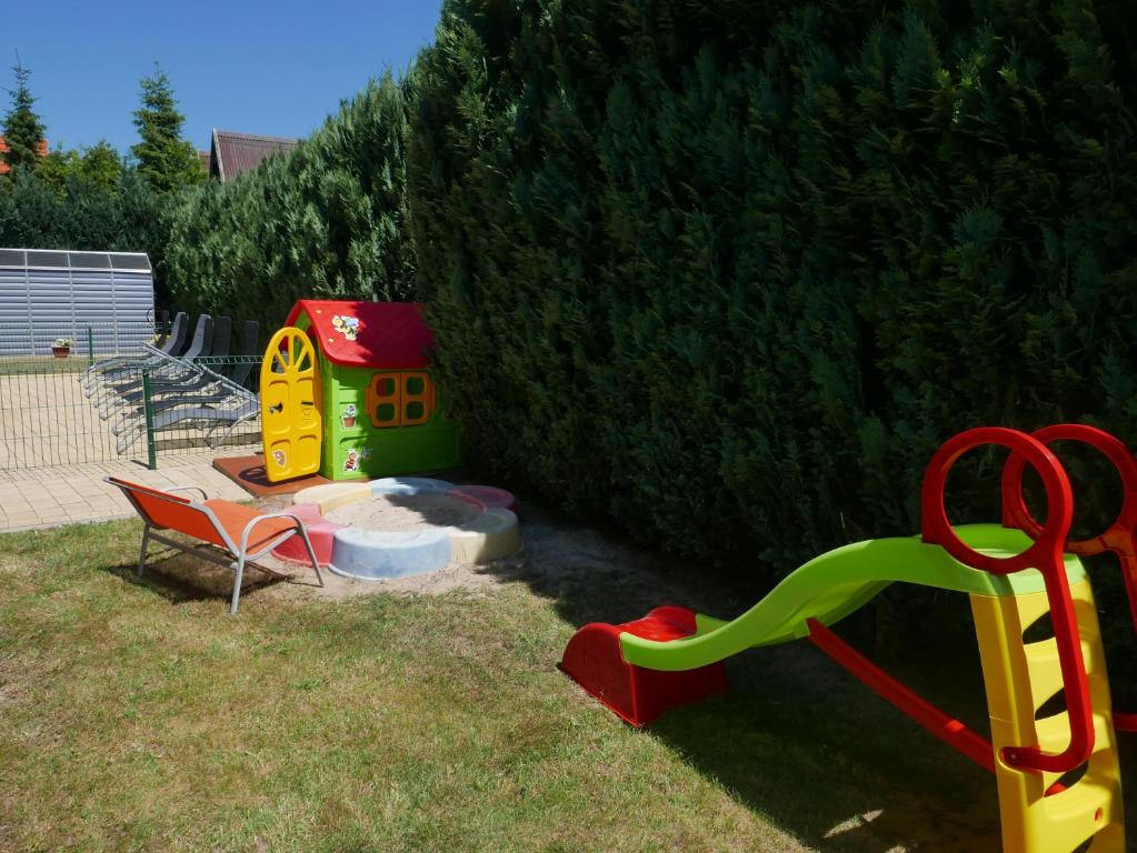 plac zabaw ze zjeżdżalnią i krzesłem na dziedzińcu w obiekcie Ferienhäuser mit Pool w Rewalu