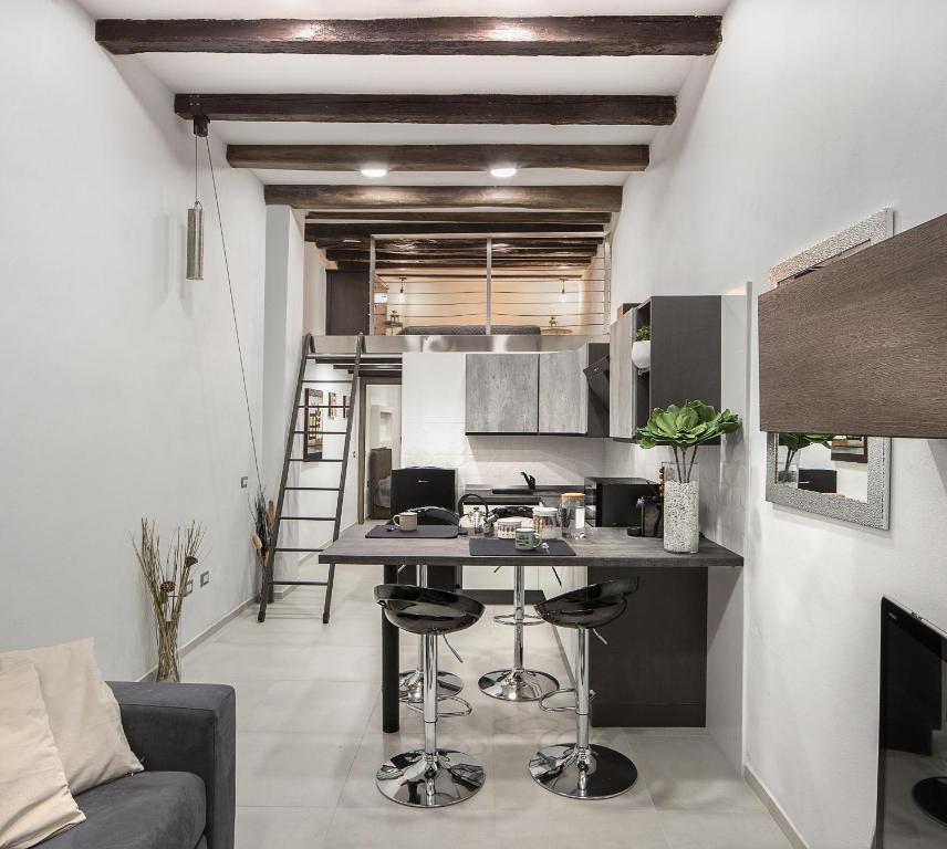 uma cozinha com mesa e cadeiras num quarto em Host 98 em Cagliari