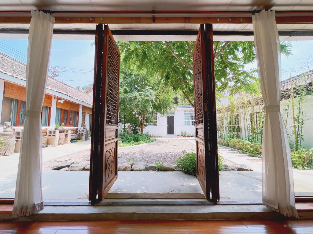 une porte ouverte menant à un bâtiment avec une cour dans l'établissement B&B under Great Wall, à Huairou