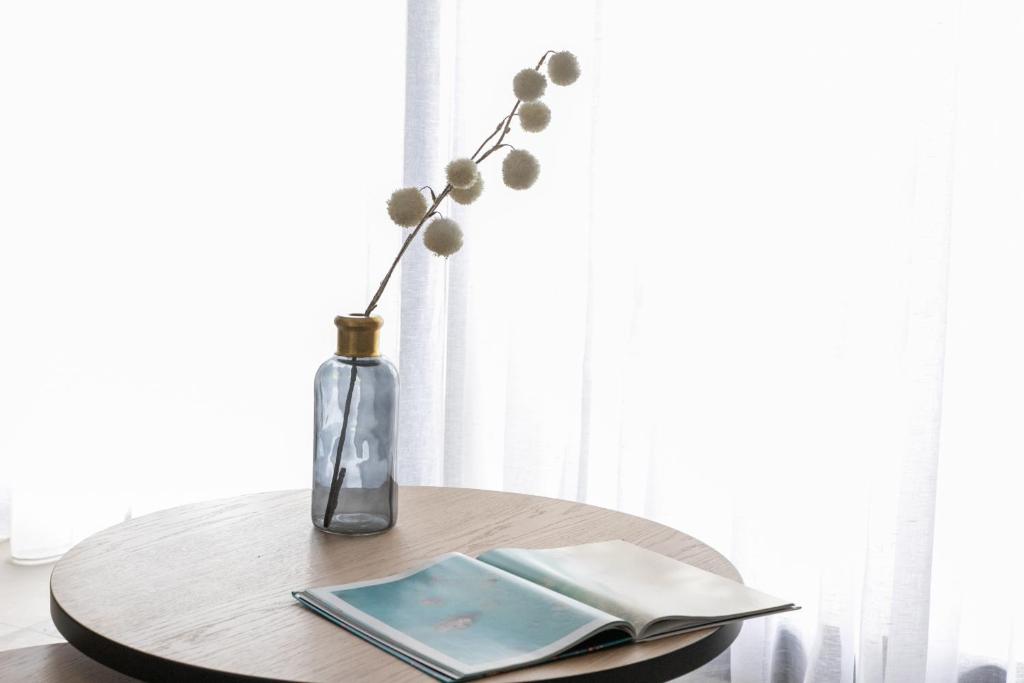 a table with a vase with a flower in it at The Euphoria Club Luxury Villas in Pefkochori