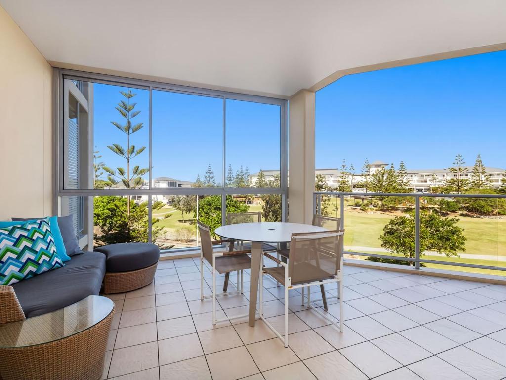 a living room with a table and a couch at Coast Culture 1208 Apartment with complex Pool & Spa in Kingscliff