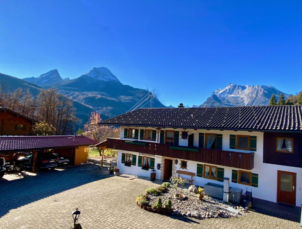 un grande edificio con montagne sullo sfondo di Berghof Punzenlehen - nahe Königssee a Bischofswiesen