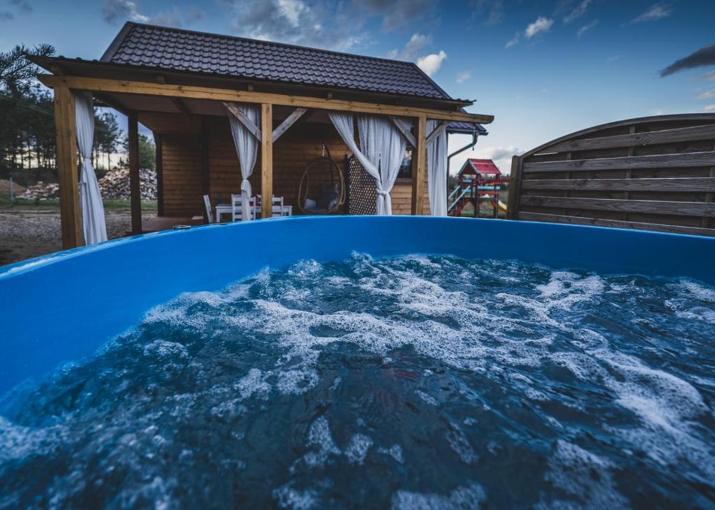 a view of a pool with a gazebo at Domki u Danusi z widokiem na wodę in Lipusz