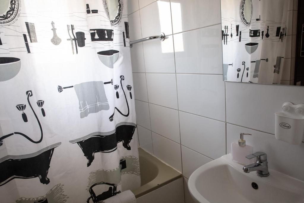 a bathroom with a shower curtain and a sink at Olive Island in Larnaka