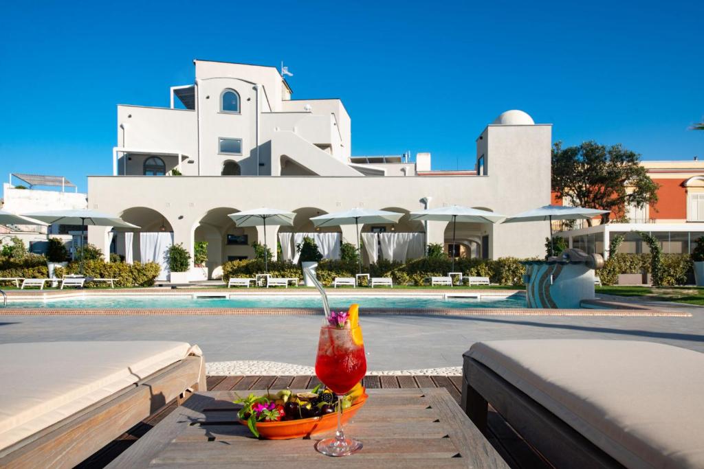 a drink sitting on a table in front of a pool at Insula Boutique Hotel in Procida