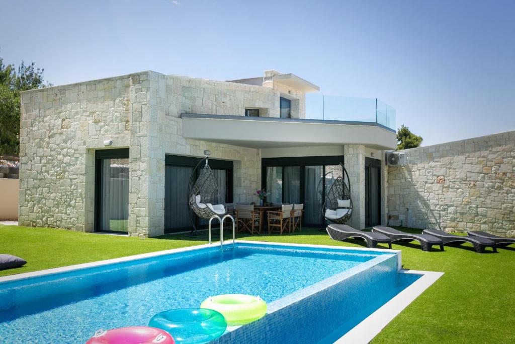 une maison avec une piscine dans la cour dans l'établissement The Euphoria Club Luxury Villas, à Pefkohori
