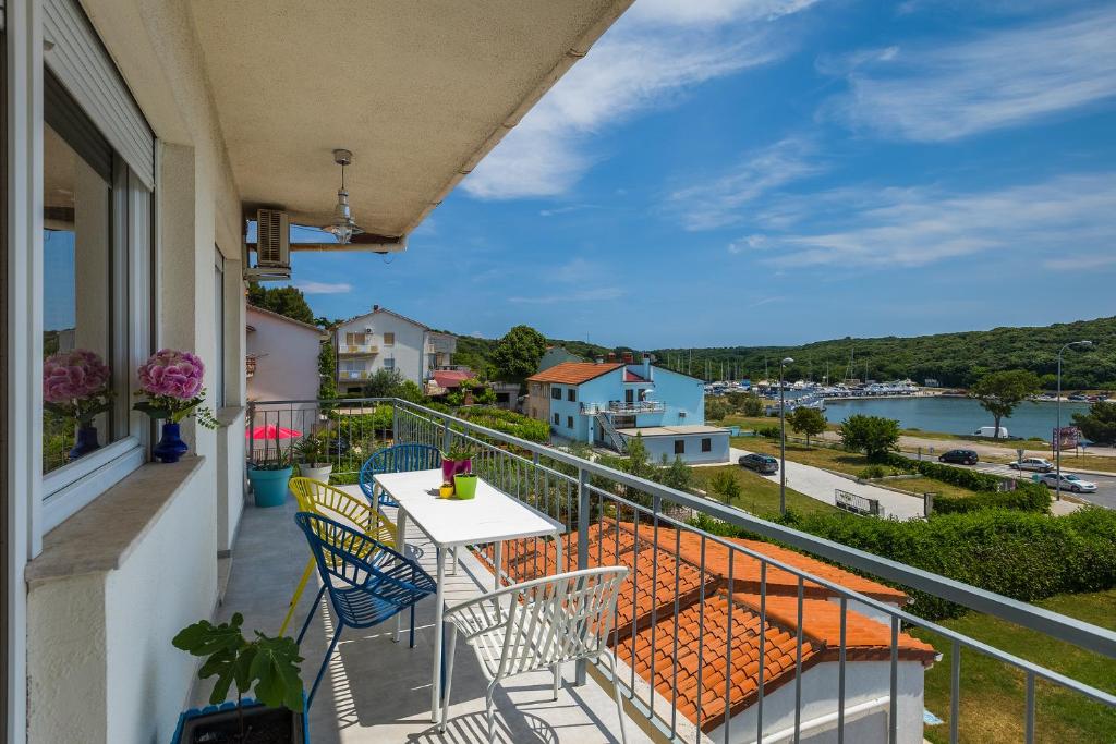 balkon ze stołem i krzesłami oraz widokiem na wodę w obiekcie Salt&Sky w Puli