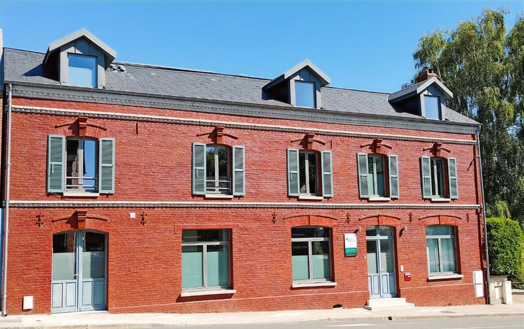 a red brick building with white shuttered windows at Le Relais des 4 Saisons - Chambres d'hôtes B&B en Baie de Somme in Saint-Valéry-sur-Somme