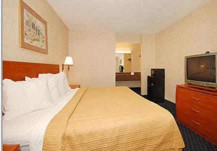 Habitación de hotel con cama y TV de pantalla plana. en Greenville Inn & Suites en Greenville