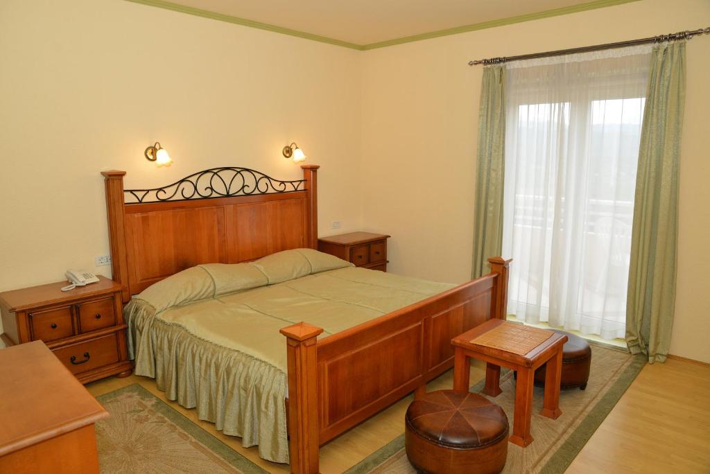 Un dormitorio con una gran cama de madera y una ventana en Hotel Venezia Imotski, en Imotski