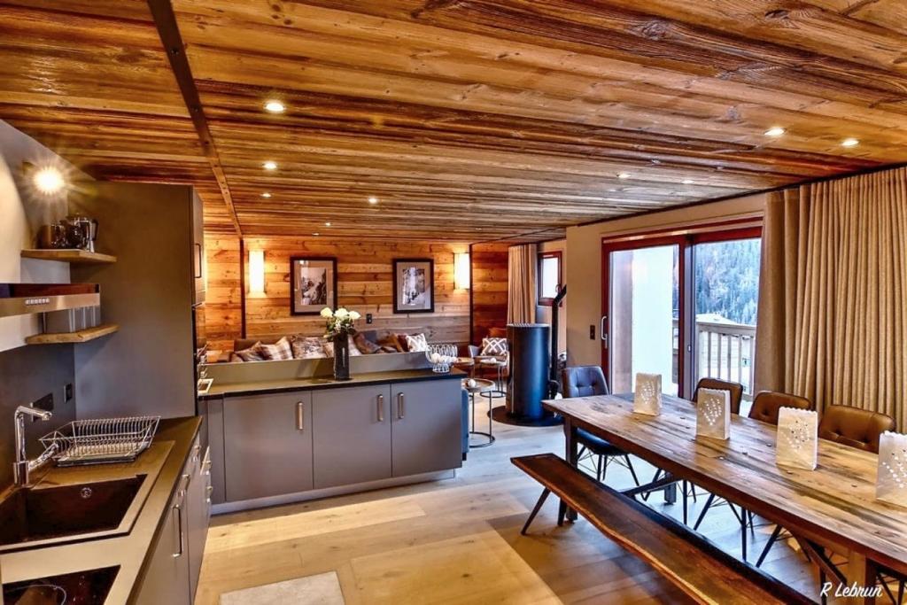 eine Küche und ein Esszimmer mit Holzdecke in der Unterkunft Astraea in Peisey-Nancroix