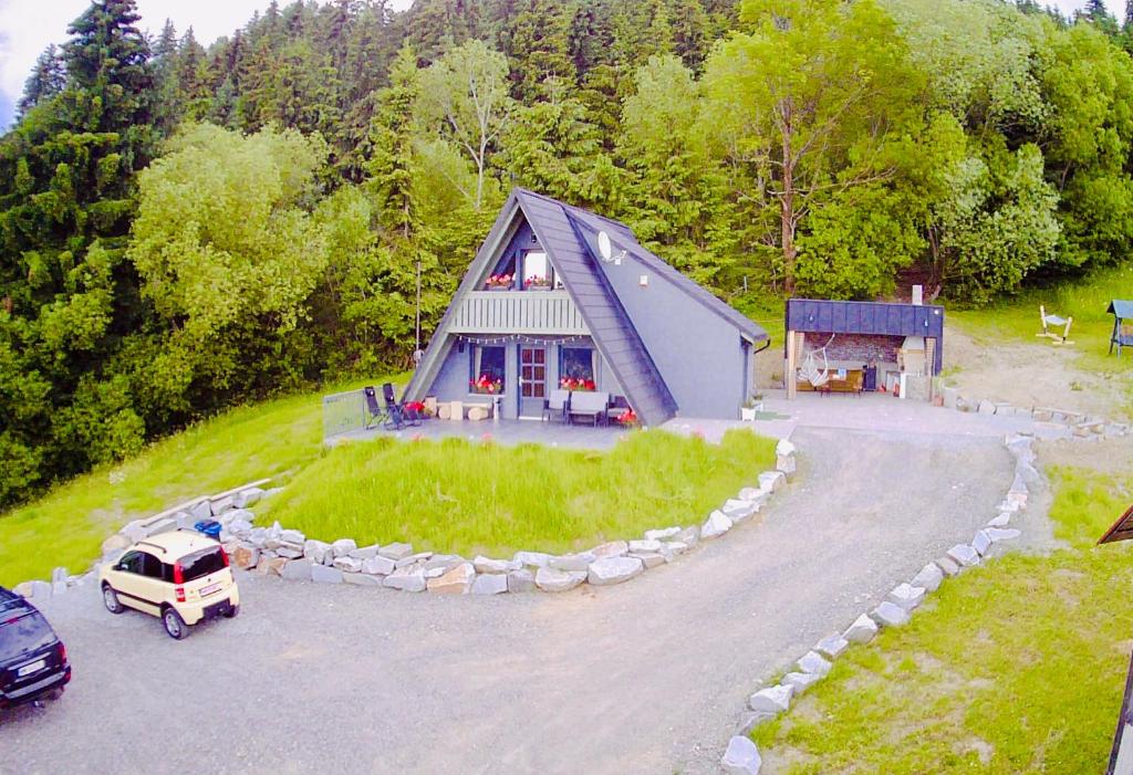 eine Luftansicht eines Hauses mit einem davor geparkt in der Unterkunft Cabana Doinița in Borşa