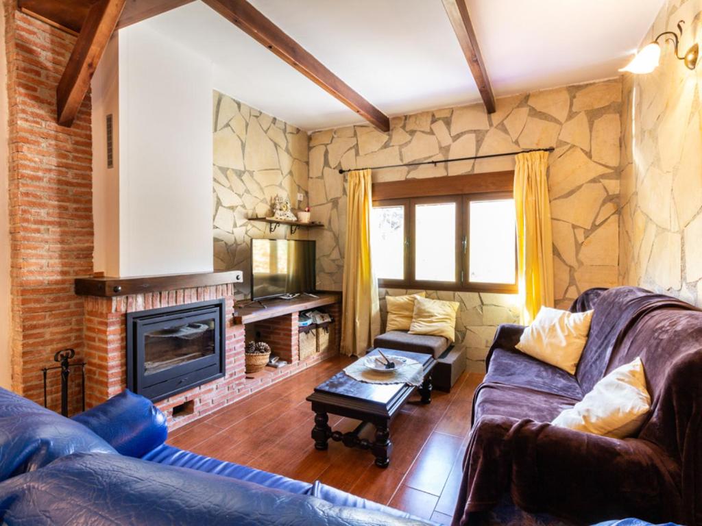 een woonkamer met twee banken en een open haard bij Casa del rio in Saleres