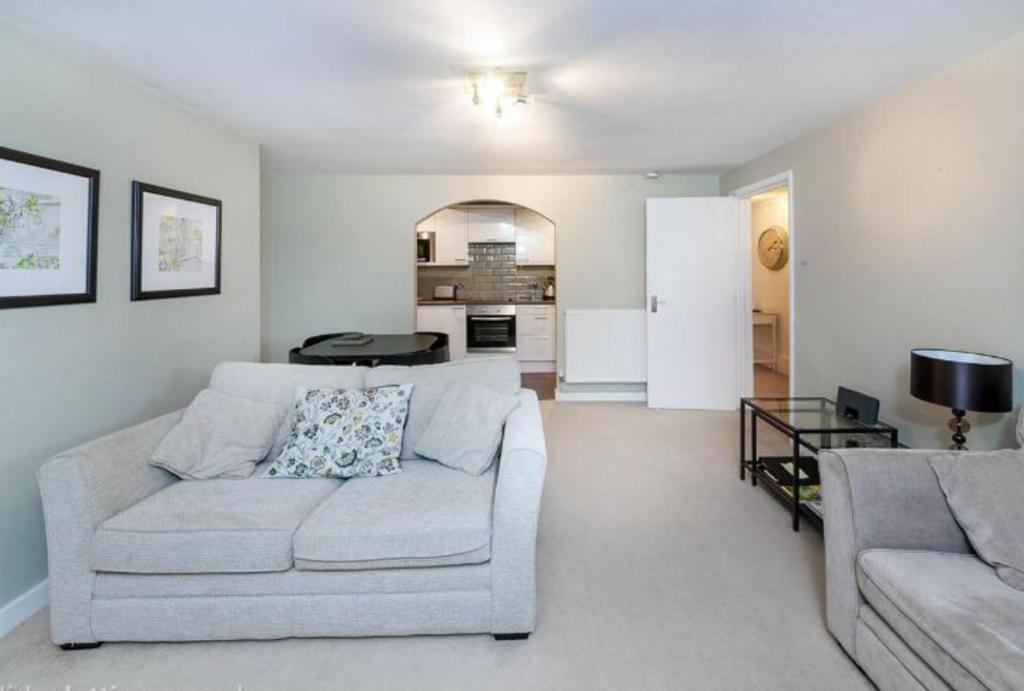 a living room with a couch and a table at Garden Flat in Royal Tunbridge Wells