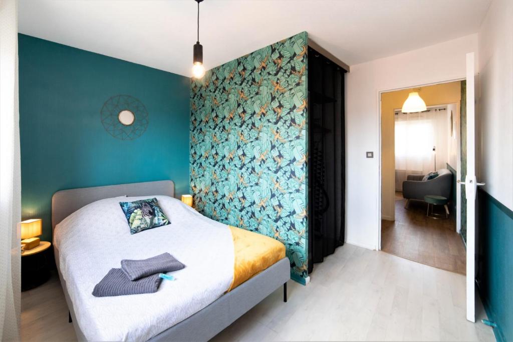 une chambre avec un lit avec un mur bleu dans l'établissement JANA HOUSE - HYPERCENTRE - GARE - NETFLIX, à Toulouse