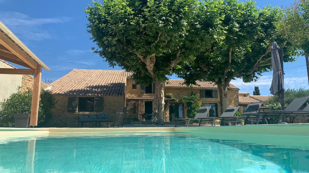 uma villa com piscina em frente a uma casa em Le Mas Andoli em Tresques
