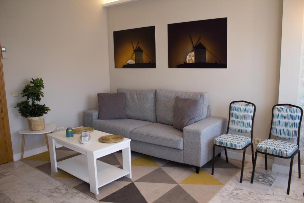 a living room with a couch and two chairs at Apartamento Vistas molineras in Consuegra