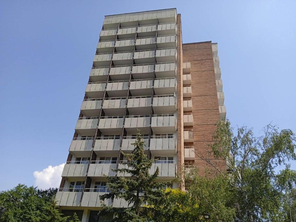 a tall apartment building with trees in the foreground at Hotel Park in Burgas City