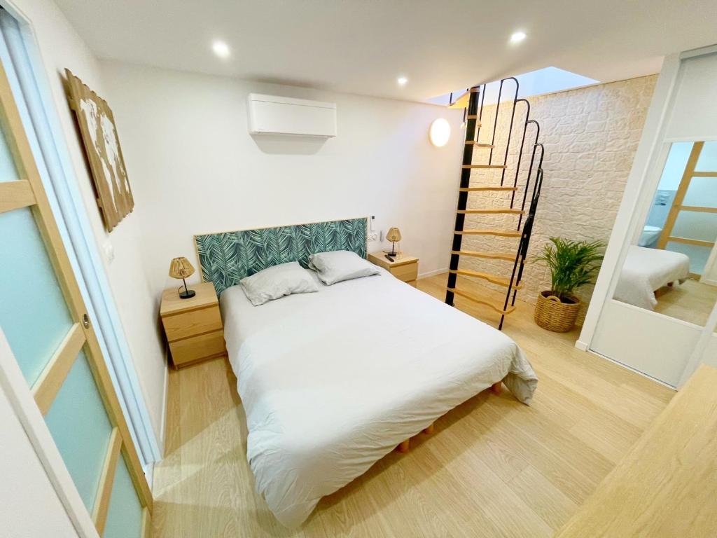 une chambre avec un lit blanc et un escalier dans l'établissement Saint Paul de Vence - LE KUB PLEX, à La Colle-sur-Loup