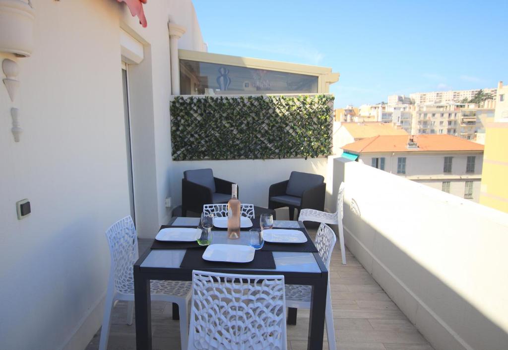 een tafel en stoelen op het balkon van een gebouw bij La terrasse de Carras in Nice