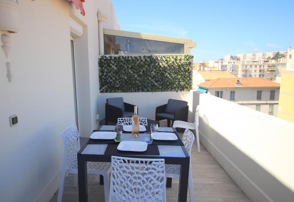 une table et des chaises sur le balcon d'un bâtiment dans l'établissement La terrasse de Carras, à Nice